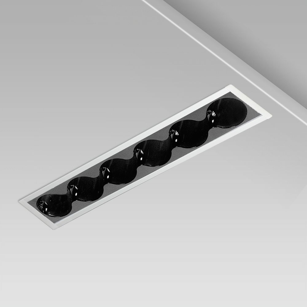 incasso a soffitto lineare per l'illuminazione di interni dall’eleganza minimalista, con cornice sporgente e ottica tonda nera ad abbagliamento controllato